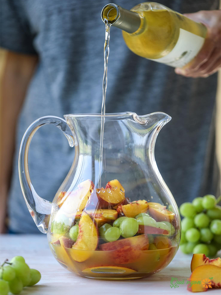 Đổ rượu Pinot Grigio, nước ép đào và nước soda lên trên trái cây