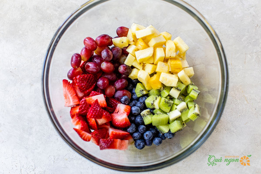 Cho tất cả trái cây vào một bát lớn bao gồm: dâu tây, dứa, việt quất, kiwi và nho. 